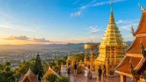 Sunrise view from Wat Phra That Doi Suthep overlooking Chiang Mai, Thailand, with the city's skyline and surrounding mountains.