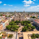 Panoramic view of Mérida, Mexico, featuring colorful colonial architecture, Plaza Grande, and the historic city center on a sunny day.